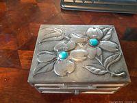 Top showing floral relief, turquoise stones, MS signature