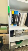 Bookcase upper and middle shelves with books for scale