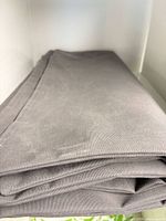 Folded grey Sunbrella cushion cover showing fabric texture