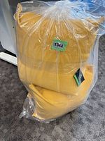Stack of four yellow cushions sealed in plastic bag