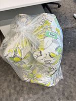 Four floral outdoor cushions in clear plastic bag