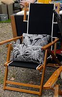 Cushion displayed on wooden patio chair, showing pattern, piping and zipper