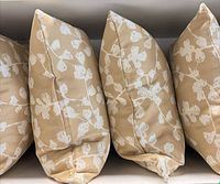 Four tan cushions with white floral pattern, side view showing fullness