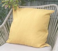 Yellow Sunbrella cushion cover on chair outdoors