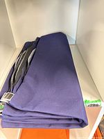 Four folded navy cushion covers showing Sunbrella fabric and zippers