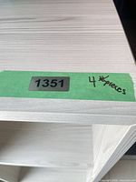 Close view of shelf top showing light wood grain laminate and lot label