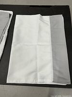 White sheet with grey trim laid flat