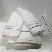 Two white towels with blue stripes folded