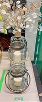Two stacked lanterns with candles showing size difference