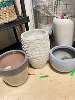 Group showing four neutral-tone planters on floor