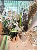Group of assorted artificial floral and foliage stems in cardboard holders and vase