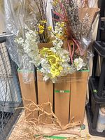 Mixed artificial floral stems bundled in cardboard box
