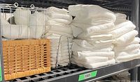 Towels stacked on shelf with wire and wicker baskets visible