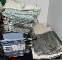 Stacked pillow covers in basket, showing patterned aqua and solid pieces