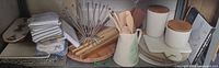 Shelf view showing towels, trays, board, utensils, canisters