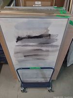 Front view of rolling cart loaded with artwork for scale
