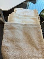All three bed scarves stacked: taupe speckled, off-white silver sparkle, off-white pom-pom trim