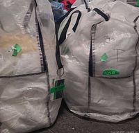 Two large white woven storage bags containing the bedding sets, tagged 342/335