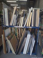 Two-tier blue metal art cart loaded with framed artwork (art not included)
