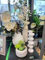 Group shot showing all three white vases with faux florals and both white candlesticks