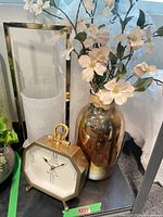 Clock, vase with faux flowers, candle holder in frame