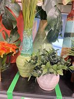 Large mint green vase, small green ribbed vase, small off-white planter with faux plants