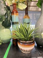 Tall and small vases with faux plants visible