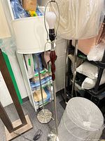 Two brushed nickel floor lamps with shades, wood accent visible on front lamp