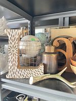 Shelf with carved letter L, decorative spheres, bronze vase, faux antler, wooden letter a