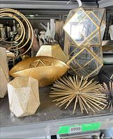 Shelf with gold bowl, orb, starburst, faceted vases, mirrored tower