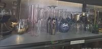 Shelf view showing mixed glassware sets and shaker