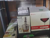 Boxed Stokes carafe, Spiegelau glass set, decorative string lights visible on shelf