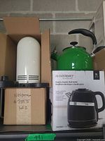 Overall view of Nespresso unit in box, green stovetop kettle, JS Gourmet kettle box