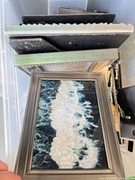 Stack of assorted small frames including brushed metal and black finishes