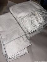 Pair of white terry bath towels with damask cuffs stacked
