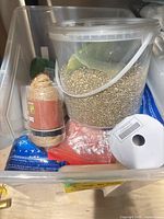 Bin exterior showing tub of filler, jute twine, ribbon roll and other supplies