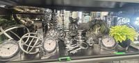 Shelf with assorted silver decor including clocks, orbs, candlesticks, pineapple, leaf sculpture