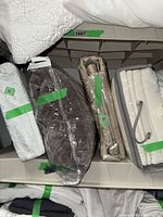 Shelf view showing multiple packaged king duvet sets and folded coverlet
