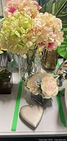 Overall lot view showing both vases with faux florals and heart box