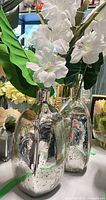 Two mercury glass vases with faux orchids and foliage