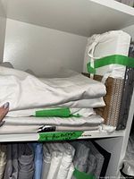 Stacks of white and beige pillowcases, plus packaged sets on shelf