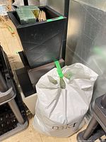 Three nested square metal planters with bag of artificial moss in foreground