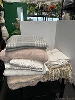 Stack of ten throw blankets showing colours and textures
