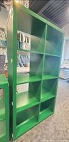 Front view of one green IKEA Kallax 8-cube shelving unit