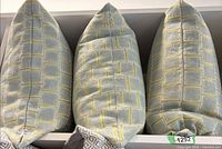 Three Kravet cushions in shelving unit