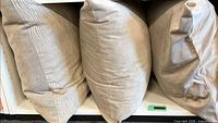 Three pillows side-by-side on shelf showing fronts and thickness