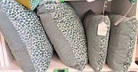 Four pillows on shelf showing shapes and pattern