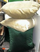Stacked ivory and green velvet pillows showing color and texture