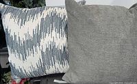Solid grey and patterned white-blue pillows side by side