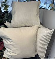 Group of four off-white throw pillows on sofa